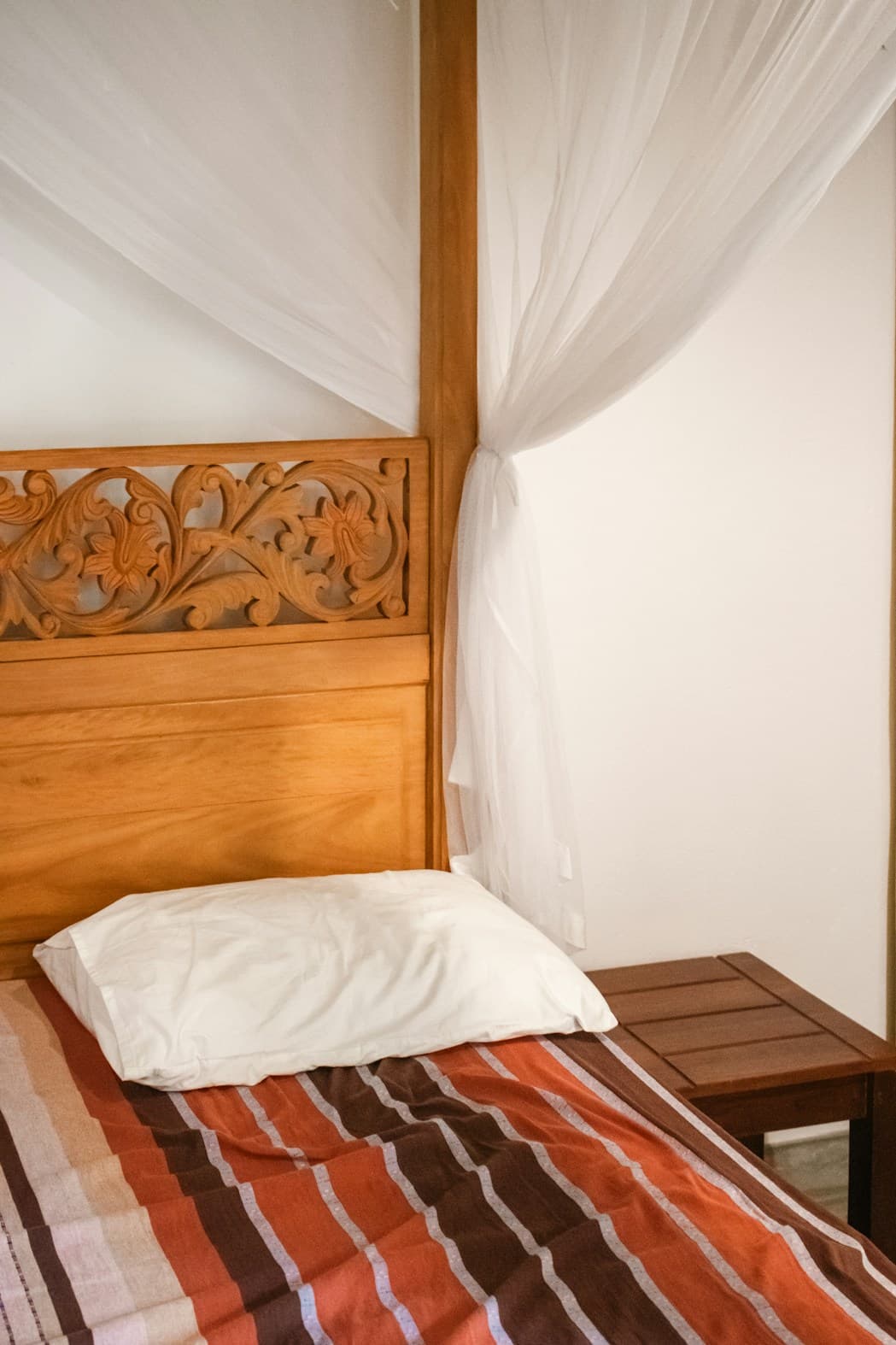 Chambre avec tête de lit sculptée et décoration chaleureuse
